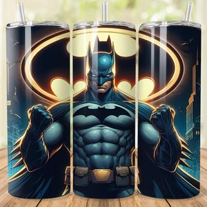 May include: A tumbler featuring Batman in a dynamic pose, set against a cityscape backdrop. The design showcases Batman's iconic emblem in a golden hue, with a dark blue and black color scheme. The tumbler includes a straw.