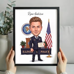 May include: A framed caricature illustration of a police officer named Ryan Anderson in a dark blue uniform holding a graduation certificate. The background features an Illinois State Police emblem, a podium, a table, and an American flag.