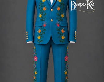 May include: A bright blue suit featuring a white collared shirt underneath. The jacket and trousers are decorated with embroidered floral patterns in pink, yellow, and green. The jacket has two gold buttons and the text Stitchery Bespoke.