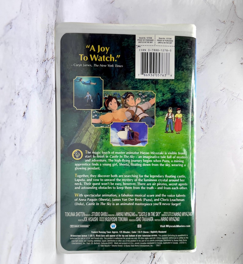 May include: The back of a VHS tape for the animated film "Castle in the Sky." The cover displays colourful illustrations of characters and scenes from the movie, with text including the title and a quote from The New York Times.