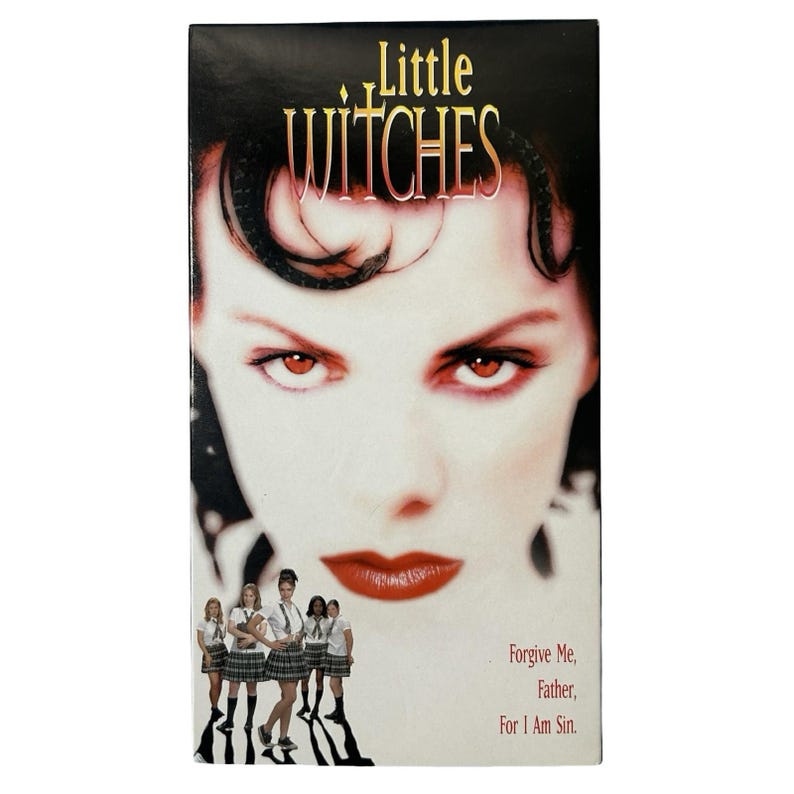 Może przedstawiać: Prostokątna okładka kasety VHS do filmu Little Witches. Okładka przedstawia duże zbliżenie twarzy z intensywnymi pomarańczowymi oczami i czerwonymi ustami. Poniżej stoi pięć os&oacute;b w mundurkach szkolnych. Tekst głosi Little Witches oraz Forgive Me, Father, For I Am Sin.