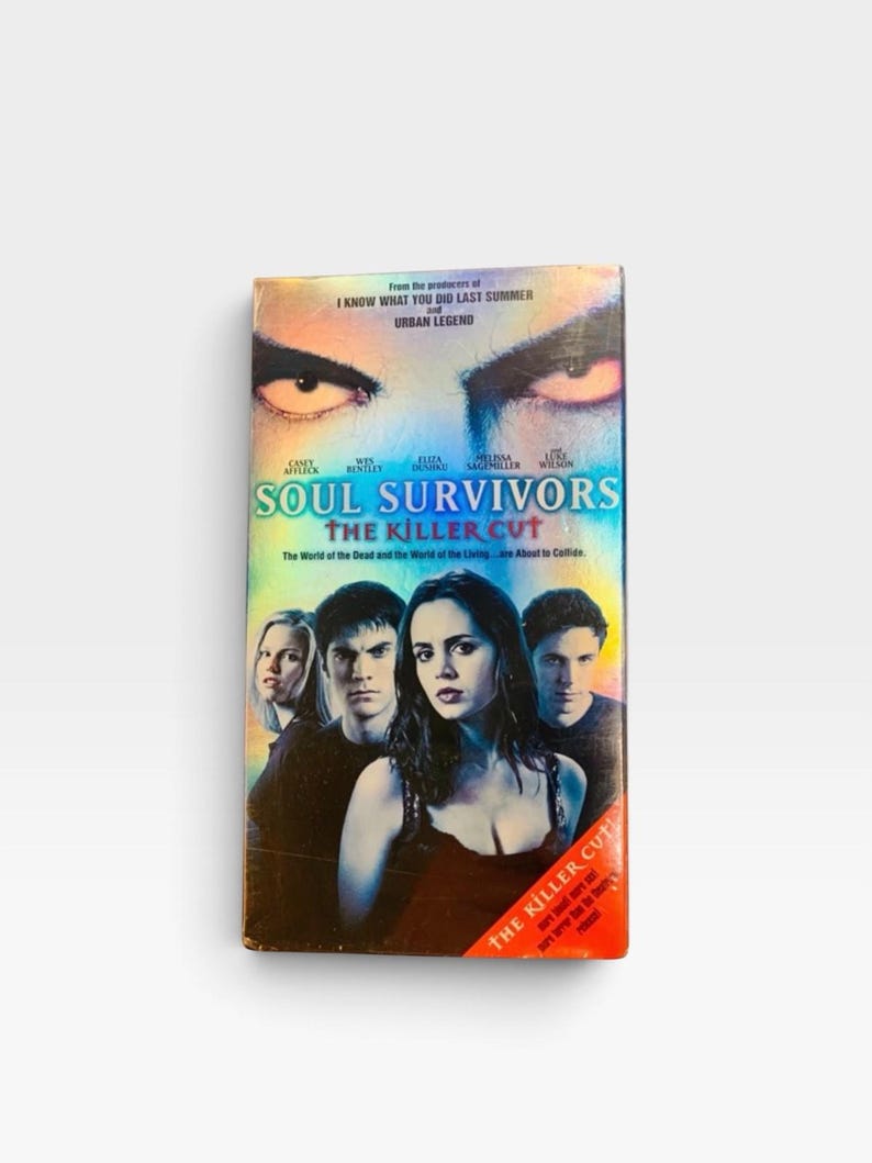 Może przedstawiać: Kaseta VHS z filmem Soul Survivors: The Killer Cut. Okładka przedstawia parę intensywnych oczu u g&oacute;ry, tytuł niebieską czcionką oraz czworo aktor&oacute;w na pierwszym planie. Czerwony ukośny pasek na dole zawiera napis The Killer Cut.