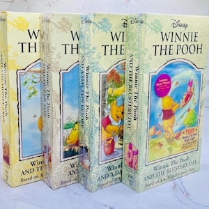 Peut inclure: Quatre cassettes VHS vintage de Disney Winnie l'Ourson. Les dos et les couvertures sont jaune clair et bleus avec des illustrations de Winnie et ses amis. Les titres incluent "The Honey Tree", "Tigger Too", "A Day for Eeyore" et "The Blustery Day".