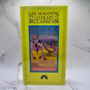 Puede incluir: Caja de cinta VHS amarilla con el título "Mr. Magoo's Literary Classics" y una ilustración de Don Quijote de la Mancha. El logotipo de Paramount está en la parte inferior. La caja está sellada en plástico.