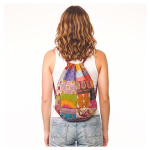 May include: A drawstring backpack featuring a patchwork design composed of various colorful fabric squares. The bag displays a mix of patterns including paisley, geometric shapes, and floral motifs in shades of orange, purple, pink, and blue.