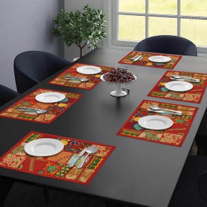 May include: A dining table set for six with red placemats featuring a patchwork design. Each place setting includes a white plate and silverware. A decorative bowl of fruit sits in the centre.