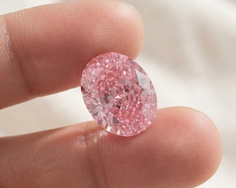 Könnte beinhalten: Ein oval geschliffener Edelstein mit einem leuchtend rosa Farbton und einer facettierten Oberfläche, die das Licht reflektiert. Der Stein hat eine symmetrische Form mit zahlreichen dreieckigen und rautenförmigen Facetten, die für ein brillantes Funkeln sorgen.