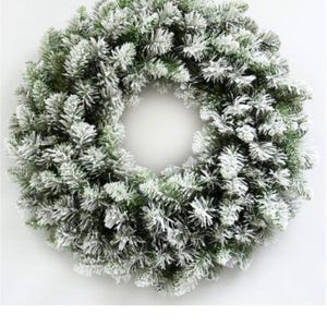 May include: A circular artificial wreath constructed from dense green pine needles. The tips of the needles are coated in a thick white flocking material, creating a snowy appearance throughout the entire structure of the round evergreen decoration.