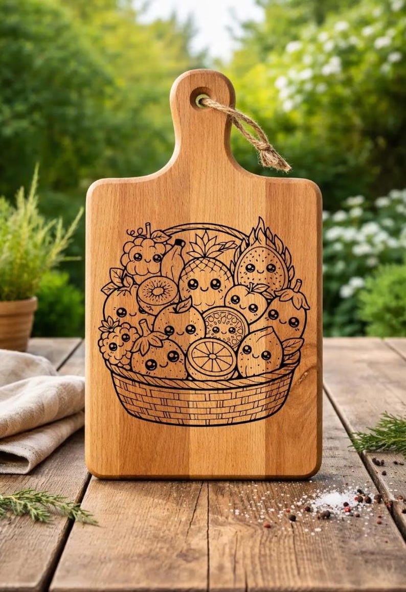 Puede incluir: Tabla de cortar de madera con asa y un dise&ntilde;o grabado de una cesta llena de frutas de dibujos animados sonrientes. Las frutas incluyen pi&ntilde;a, naranjas, fresas y m&aacute;s. La tabla es de madera clara.