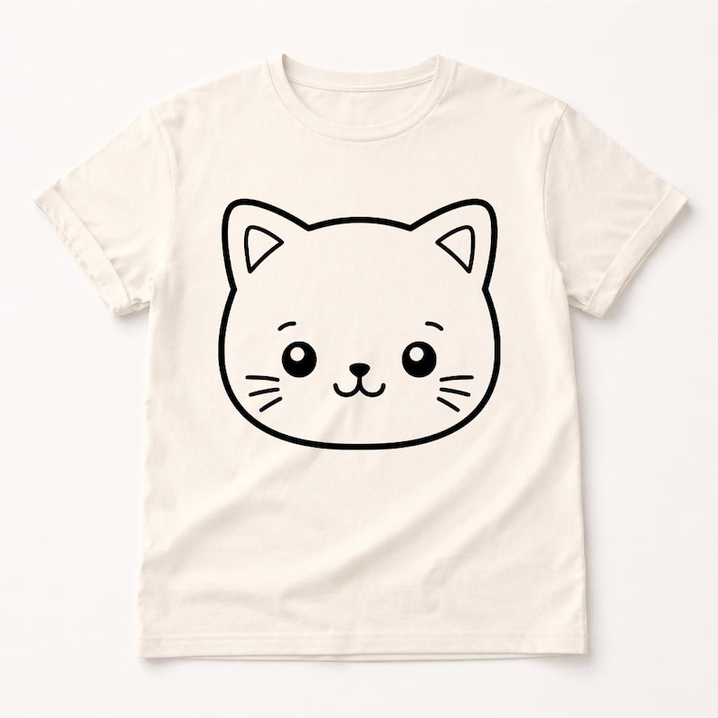 Puede incluir: Camiseta de color crema con un gran contorno negro de una cara de gato de dibujos animados. El gato tiene ojos grandes, bigotes y una boca sonriente. La camiseta tiene mangas cortas y cuello redondo.