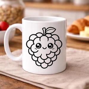 Puede incluir: Taza de cer&aacute;mica blanca con una ilustraci&oacute;n en contorno negro de una frambuesa sonriente, con tallo y hoja. La taza tiene un asa curva y est&aacute; colocada sobre una superficie de madera. Un tarro de frutos secos y un cruas&aacute;n est&aacute;n en el fondo.