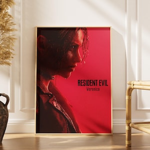 Può includere: Un poster da parete rettangolare che presenta un ritratto di profilo di una persona con capelli scuri su uno sfondo rosso vibrante. Il testo Resident Evil Veronica è stampato in nero nel quadrante in basso a destra del poster, che è incorniciato.