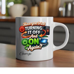 May include: White ceramic mug with a tech-related joke. The mug displays the text "Have you tried TURNING IT OFF And ON Again?" alongside illustrations of a power button, a computer tower, and a laptop. The name "George" is printed on the mug.