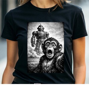 May include: Black t-shirt with a monochrome graphic of a retro robot and a startled monkey. The robot is in the background, and the monkey is in the foreground with its mouth open. The design has a vintage, distressed appearance.