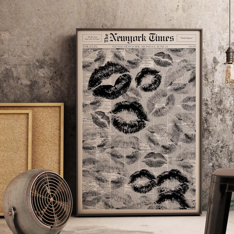 Puede incluir: Un cuadro enmarcado con un fondo de peri&oacute;dico vintage con m&uacute;ltiples marcas de besos de l&aacute;piz labial negro. El peri&oacute;dico tiene el titular "The Newyork Times" con la fecha "LUNES 21 DE JUNIO". El cuadro tiene un marco negro.