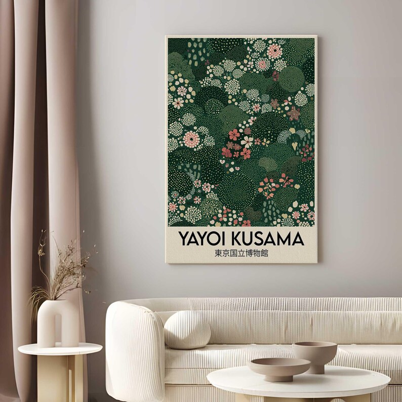 May include: A framed art print featuring a floral design in shades of green, pink, and white. The print includes the text "YAYOI KUSAMA" and Japanese characters. The artwork is displayed in a living room setting.