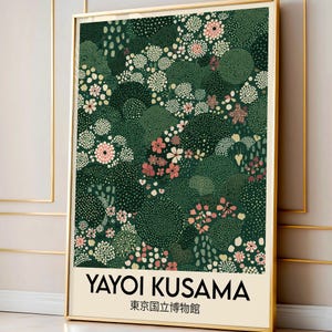 May include: A framed art print featuring a floral pattern in shades of green, pink, and white. The print includes the text "YAYOI KUSAMA" and Japanese characters. The artwork is displayed in a gold frame.