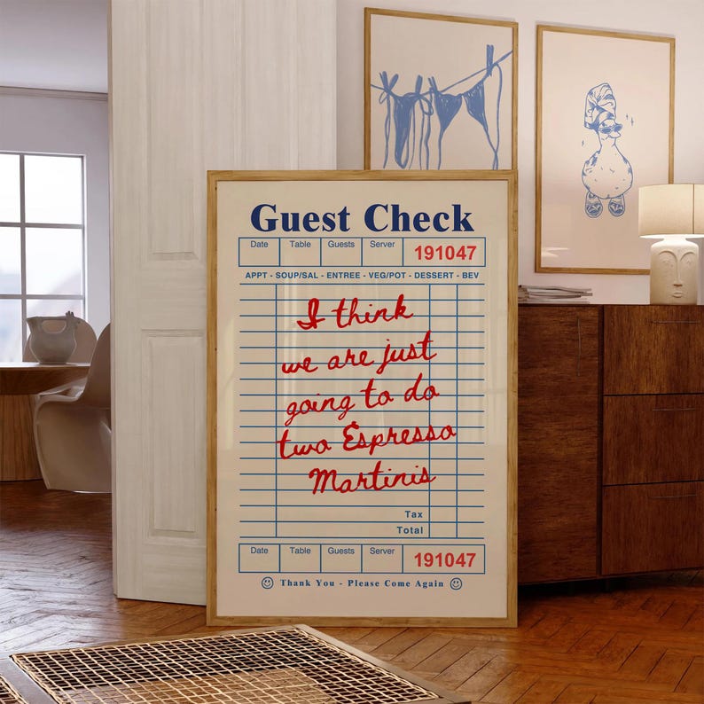 Pu&ograve; includere: Una stampa incorniciata di una ricevuta del ristorante con linee a griglia blu e testo. Il testo recita "Guest Check" in alto, seguito da testo rosso scritto a mano: "I think we are just going to do two Espresso Martinis."