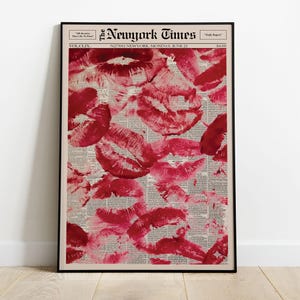 Pu&ograve; includere: Stampa incorniciata con un collage di impronte di baci di rossetto rosso su uno sfondo di giornale. Il giornale &egrave; datato 21 giugno, con il titolo "The Newyork Times" in alto. La stampa &egrave; in una cornice nera.
