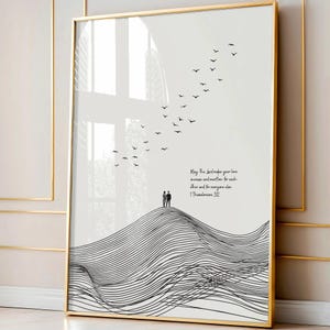 May include: Gold-framed art print with a minimalist design. The artwork shows a stylized mountain range, two figures, a flock of birds, and inspirational text. The frame is gold.