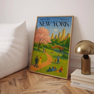 May include: A framed art print featuring a vintage illustration of New York City's Central Park. The artwork depicts a park scene with people, a bridge, and a cityscape in the background. The print includes the text "APRIL 25, 1994" and "NEW YORK".