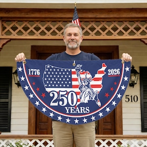 May include: A blue and white banner with the text "1776" and "2026" on either side of a map of the United States. The map features the American flag and the Statue of Liberty. The banner also reads "250 YEARS".