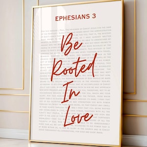 Könnte beinhalten: Gerahmter Kunstdruck mit dem Text "Epheser 3" oben. Die Worte "Be Rooted In Love" sind in einer dekorativen Schriftart auf einem Hintergrund aus gedrucktem Text geschrieben. Der Druck befindet sich in einem goldenen Rahmen.