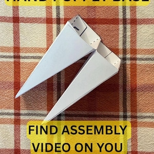 May include: Two white paper hand puppet bases with triangular shapes and visible fold lines. The text HAND PUPPET BASE is at the top, and FIND ASSEMBLY VIDEO ON YOU TUBE is at the bottom. The paper structures are pointed and hollow.