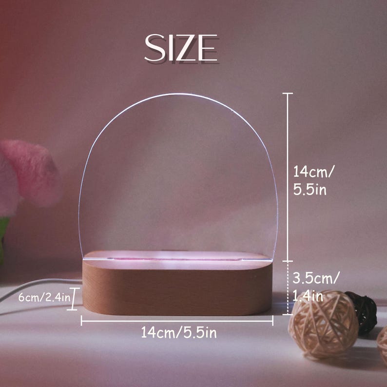 Op de afbeelding: Een decoratieve LED-lamp met een gebogen bovenkant en een rechthoekige basis. De lamp is 14 cm breed en 14 cm hoog, met een basis van 3,5 cm hoog. De tekst "SIZE" staat bovenaan.