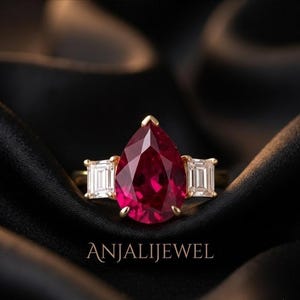 Anello di fidanzamento con rubino a forma di pera e moissanite a baguette affusolata, in oro giallo 14 carati, con tre pietre.