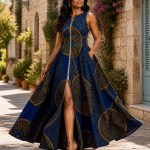 Peut inclure: Une robe longue bleue sans manches avec un motif circulaire doré et marron. La robe est dotée d'une fermeture éclair sur le devant et d'une fente haute, portée avec des talons dorés.