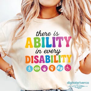 May include: Cream-coloured sweatshirt with the text "there is ABILITY in every DISABILITY" in colourful letters. Below the text are several colourful icons. The sweatshirt is a crew neck style.