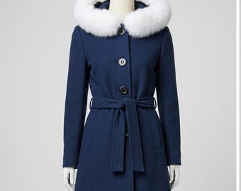 May include: A navy blue coat with a white faux fur trimmed hood. The coat has a belted waist, button closures, and long sleeves. This winter coat is a stylish outerwear option.