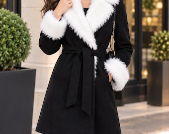May include: A black coat featuring a wide white faux fur collar and matching white faux fur cuffs on the long sleeves. The coat has a tie-waist belt made of the same black fabric, a lapel neckline, and a length that reaches the mid-thigh.