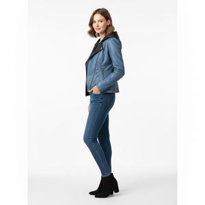 Puede incluir: Chaqueta de cuero azul claro con capucha negra y cierre de cremallera. La chaqueta se combina con vaqueros azules y botines negros. La modelo est&aacute; de pie frente a un fondo blanco.