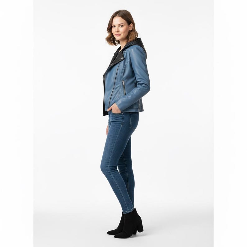 Puede incluir: Chaqueta de cuero azul claro con capucha negra y cierre de cremallera. La chaqueta se combina con vaqueros azules y botines negros. La modelo est&aacute; de pie frente a un fondo blanco.