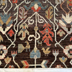K&ouml;nnte beinhalten: Ein dunkelbrauner Teppich mit einem sich wiederholenden Muster aus stilisierten Blumenmotiven, Bl&auml;ttern und kleinen Vogelfiguren in Rot-, Blau-, Beige- und Cremet&ouml;nen. Das Design ist symmetrisch mit wei&szlig;en, rankenartigen Linien zwischen den Elementen.