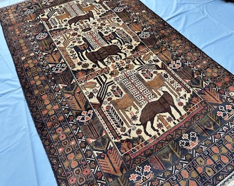 Könnte beinhalten: Ein rechteckiger Teppich mit einem cremefarbenen Mittelfeld, das mit wiederkehrenden Tierfiguren wie Lamas und anderen Vierbeinern verziert ist, durchsetzt mit geometrischen Baummotiven und einer dunkelbraunen Bordüre mit komplexen Mustern.