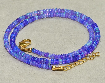May include: A delicate necklace composed of small, iridescent blue-purple beads. The necklace features a gold-colored clasp and an extender chain. The beads have a subtle shimmer, creating a captivating visual effect. The necklace is designed to be worn around the neck.