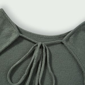 Peut inclure: Gros plan sur un haut en tricot vert sauge avec un col carr&eacute; et un d&eacute;tail de n&oelig;ud. Le tissu est doux et textur&eacute;. Le col et le n&oelig;ud sont les points centraux du design.