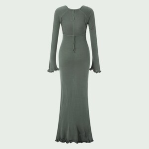 Peut inclure: Longue robe vert sauge avec manches longues et silhouette ajust&eacute;e. La robe pr&eacute;sente une encolure d&eacute;gag&eacute;e, un d&eacute;tail de n&oelig;ud dans le dos et des manches &eacute;vas&eacute;es avec des bords &agrave; volants. La robe est en tricot c&ocirc;tel&eacute;.