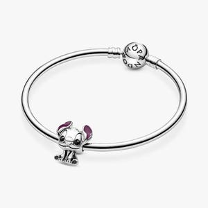 May include: A silver bracelet with a charm featuring a cartoon character with purple ears and accents. The charm is attached to a silver bangle-style bracelet. The bracelet has a round clasp with the brand name on it.