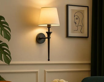 Aplique de pared moderno de metal negro con pantalla de tela blanca, iluminación elegante
