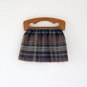 May include: A plaid fabric bag with a wooden handle. The bag is blue, white, and orange.