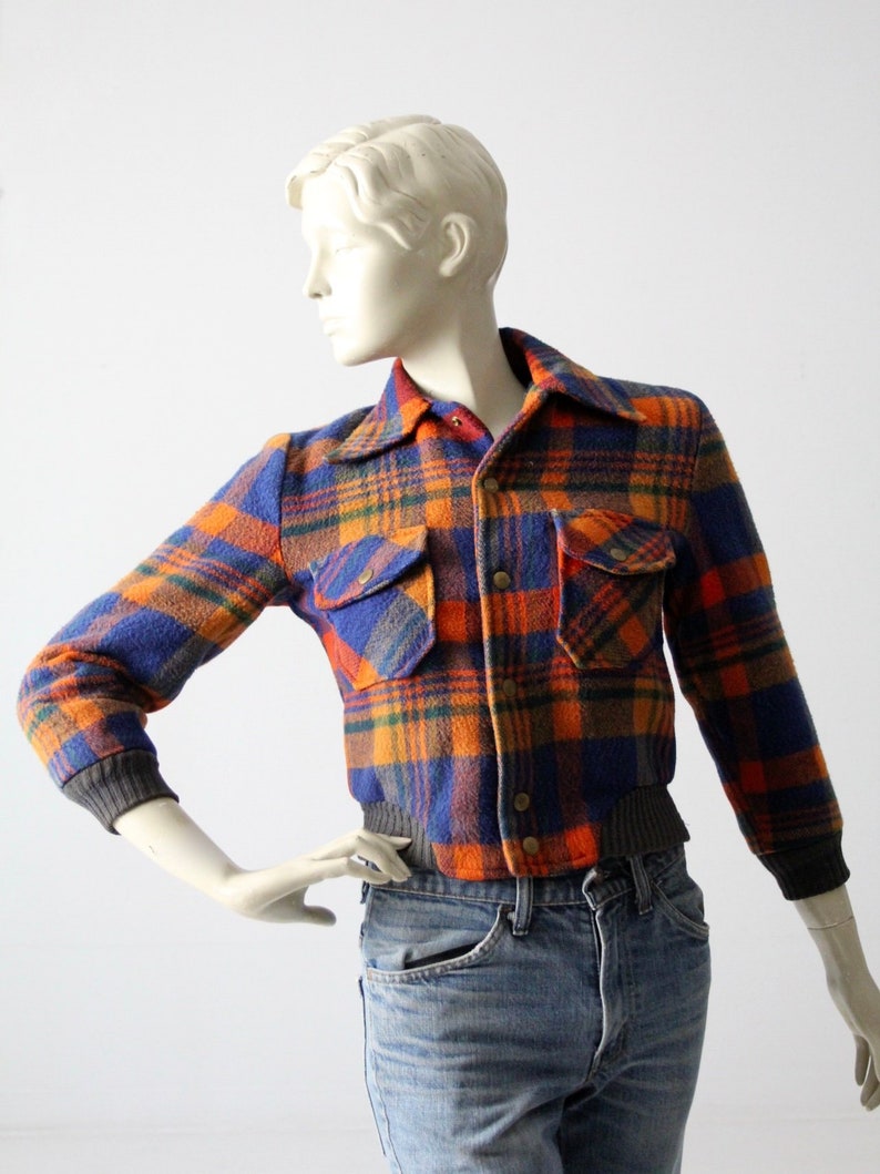 May include: A blue, orange, and green plaid flannel jacket with a button closure and two pockets. The jacket has a ribbed knit collar, cuffs, and waistband.