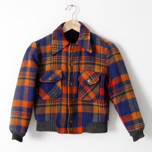 May include: A blue, orange, and brown plaid jacket with a button-up front and two large pockets. The jacket has a ribbed knit collar and cuffs.