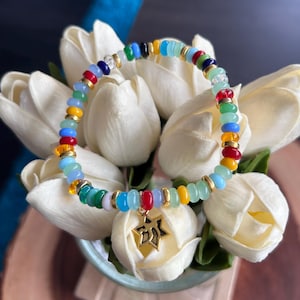 Handmade multicoloured glass bead bracelet with gold coloured spacers and star charm.