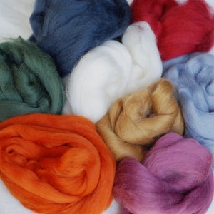 May include: A collection of eight different coloured wool rovings. The colours are: dark green, orange, dark red, light blue, white, light brown, purple, and dark blue.