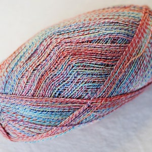 May include: A ball of yarn with a multi-colored variegated pattern in shades of pink, blue, green, and white.