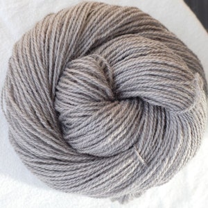 Puede incluir: Un ovillo de hilo gris, perfecto para tejer o hacer ganchillo.